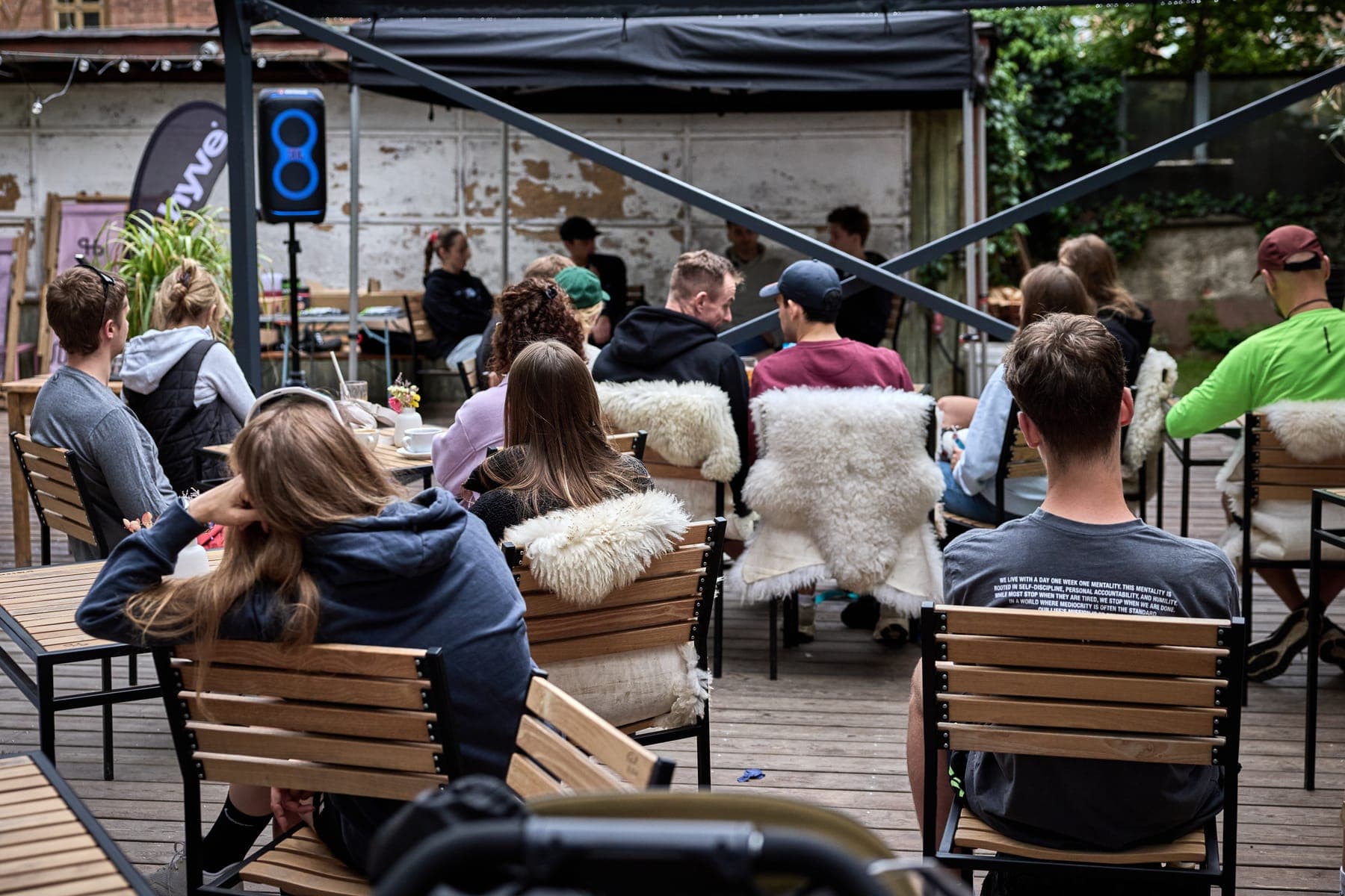 Publikum na terase pod stanem, v pozadí banner Hyve