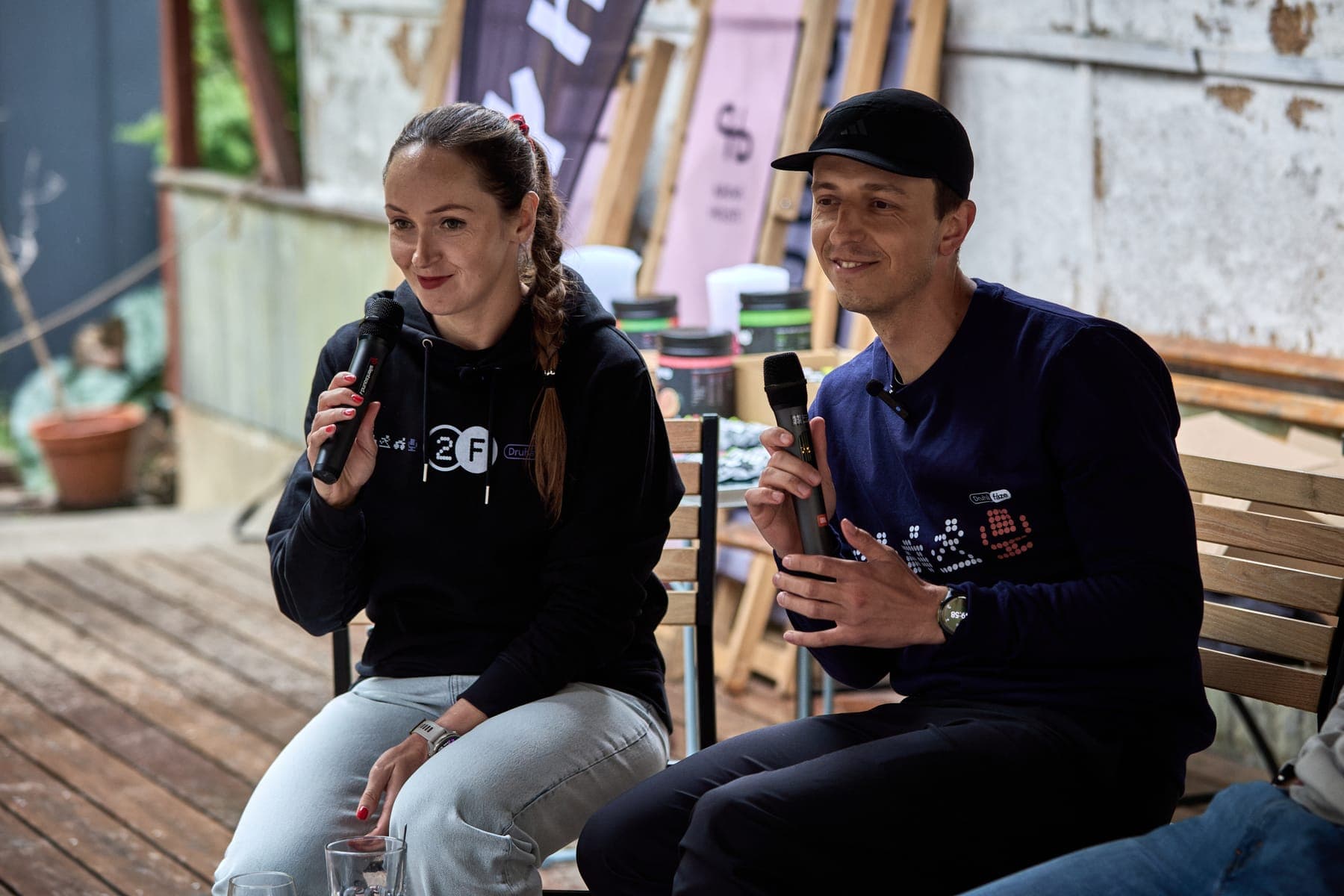 Kája a Sam se smějí, v pozadí banner Hyve a stůl s ochutnávkou